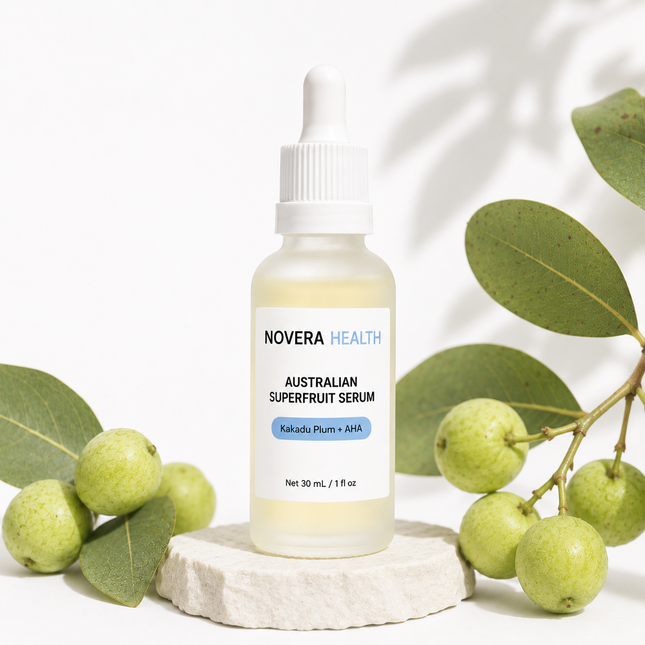 Novera Health Australian Superfruit Serum bottle styled with Kakadu Plum fruit and eucalyptus leaves on a stone pedestal