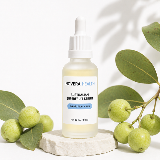 Novera Health Australian Superfruit Serum bottle styled with Kakadu Plum fruit and eucalyptus leaves on a stone pedestal